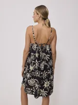 Vestido corto color naranja con estampado de motivos playeros en blanco, de breteles finos y corte suelto.