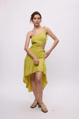 Vestido color verde lima de lino y algodón, con un hombro descubierto, corte asimétrico, volados irregulares y abertura en la cintura.