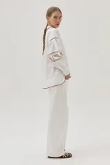 Camisa blanca de mangas largas abullonadas con bordados combinados y guardas, además de delicados bordados en el cuello y el bajo.