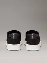 Zapatillas de perfil bajo Calvin Klein, confeccionadas en tejido de punto transpirable color negro. Presentan puntera revestida, trabilla trasera de piel y suela de goma blanca con logo grabado en la mediasuela.