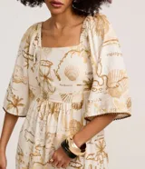Vestido midi evasê de Marfinno, confeccionado en mezcla de viscosa y lino, con estampa de mapa en tonos beige y tostado sobre base off-white. Presenta escote cuadrado, mangas amplias con detalles bordados en los bordes y corte fruncido en la cintura.