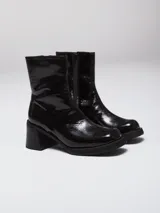 Botas de caña media con acabado charolado brillante, punta cuadrada y taco bloque. Cuentan con cierre lateral interno para facilitar su colocación.