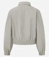 Campera deportiva de corte oversized, confeccionada en poliamida con tecnología dry. Presenta cuello camisero estructurado, cierre frontal con cremallera, bolsillos laterales, puños elásticos y ruedo con ajuste elástico.