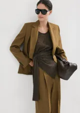 Pantalón de lino color verde militar, de corte recto y tiro bajo, con bolsillos laterales y trabillas para cinturón.