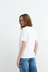Remera de algodón color beige, de manga corta y corte clásico, con estampa frontal ilustrada de un trago Daiquiri y la inscripción en letras rosadas.