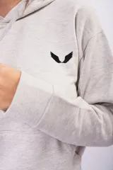 Canguro de frizza color blanco, con capucha, cordones ajustables y bolsillo frontal tipo canguro. Presenta un pequeño logo bordado en el pecho.