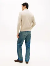 Sweater de punto color beige con cuello perkins, cierre frontal con cremallera corta y manga larga. Presenta detalles de rib en cuello, puños y dobladillo, además del logo bordado en el pecho de Tommy Hilfiger.