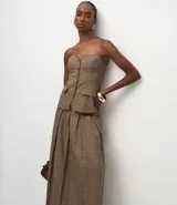 Pollera midi de sastrería con estampado de cuadros, diseño estructurado con pliegues delanteros marcados, cintura ancha con trabillas y cinturón ajustable con hebilla.