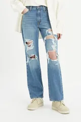 Pantalón de jean celeste con roturas grandes en ambas rodillas.