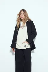 Canguro negro de silueta relajada con capucha, bolsillo canguro y estampados gráficos blancos en el pecho y las mangas.