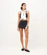Short pollera deportivo negro con estampa de lunares blancos, confeccionado en microfibra con cintura alta y short interno integrado.