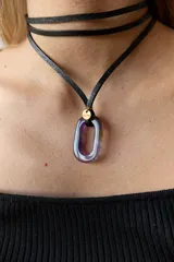 Collar con tiento negro y dije de piedra natural ovalada en tonos grises y azules.
