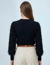 Buzo de hilado fino marca Zac & Rachel, color negro, con cuello a la base y mangas largas de gasa con bordado desflecado de textura shaggy.