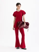 Pantalon de tejido de punto color rojo, con ajuste al cuerpo y botamanga ancha tipo oxford con detalle de pliegues verticales.