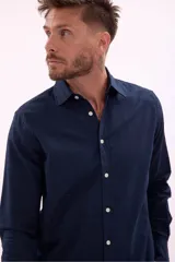 Camisa de manga larga color beige, con cuello clásico y botones frontales.