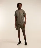 Remera deportiva de hombre, color gris claro, con cuello redondo y manga corta. Presenta un sutil efecto degradado o panel de color más claro en la zona del pecho.