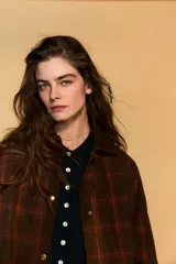 Chaqueta de mujer de la colección Zara Woman, confeccionada en algodón 100% con acabado encerado. Presenta un estampado a cuadros en tonos marrón y rojo, cuello solapa de pana, manga larga con puño y botón, bolsillos de plastrón con solapa en el delantero y cierre frontal con botones a presión.