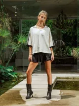 Pollera corta negra de gabardina, estilo plisado, con tiro medio y bordado frontal.