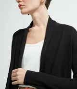 Cardigan largo de tejido de punto, color terracota, con mangas largas y diseño abierto sin cuello ni cierres.