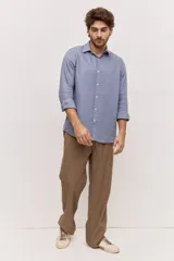 Camisa de manga larga color celeste, de corte regular y cuello clásico, con cierre frontal de botones al tono.