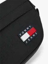 Riñonera Tommy Jeans negra de tejido ripstop, con compartimento principal con cierre, bolsillo exterior frontal con cierre, correa ajustable y parche con el logo de la marca en la parte delantera.