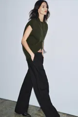 Chaleco oversize de lana color gris, con cuello redondo, manga sisa y bajo asimétrico con aberturas laterales.