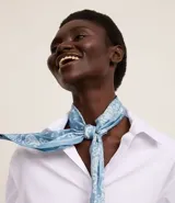 Pañuelo triangular de satén color celeste con estampado paisley en blanco.