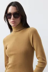 Polera de manga larga y cuello alto, confeccionada en tejido de punto fino, con un ajuste ceñido al cuerpo.