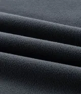 Buzo deportivo de hombre confeccionado en tejido polar (fleece) de color gris oscuro. Presenta capucha con cordones ajustables, bolsillo tipo canguro frontal, mangas largas con puños ajustados y bajo elástico. Su diseño es cerrado y cuenta con una textura suave y cálida ideal para el invierno.