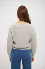 Sweater de punto en color gris claro, con cuello redondo, mangas largas y diseño de trenzas en el frente.