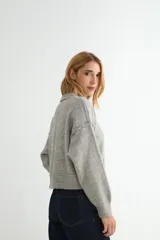 Cardigan de punto color marrón chocolate, con cuello redondo, cierre frontal de botones y diseño de costuras verticales visibles. Presenta puños y ruedo acanalados.