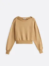 Buzo color beige de felpa de algodón con cuello barco y botones dorados en los hombros.