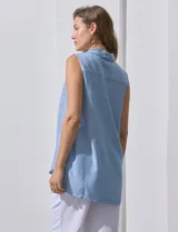 Camisa sin mangas color beige, marca Zac & Rachel, confeccionada en lino. Presenta escote en V, abertura frontal con botones, dos bolsillos delanteros y terminación con botones en los laterales.