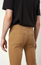 Pantalón de gabardina elastizada color camel, de calce skinny fit, con cinco bolsillos.