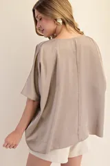 Top de corte oversized con cuello redondo y mangas cortas amplias, confeccionado en tela con acabado satinado.