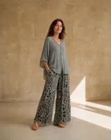 Pantalón ancho de tiro alto con estampado animal print en tonos verdes, negros y marrones, de corte fluido.