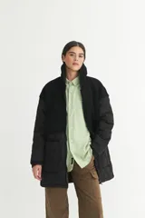 Campera negra con parte superior de sherpa y parte inferior de nylon capitoneado con forro de nylon.