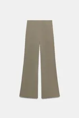 Pantalón largo negro de tiro alto, confeccionado en tejido elástico, con cintura elástica y diseño de pierna ancha tipo palazzo con bajo evasé.