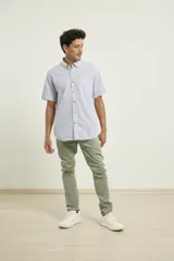 Camisa de manga corta a rayas verticales azules y blancas, con cuello abotonado y cierre frontal con botones marrones.