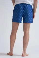 Short de baño para hombre, color azul vibrante, con estampado repetitivo de arabescos en blanco. Presenta cordón de ajuste naranja en la cintura.