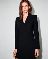 Vestido tipo blazer negro, de corte entallado y diseño cruzado con doble botonadura frontal. Presenta solapas clásicas, mangas largas y una silueta corta y estructurada.