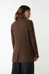 Blazer largo color crema con cuello solapa, bolsillos con solapa y forro interior combinado a tono. Confeccionado en lana fina sin teñir.