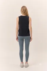 Musculosa deportiva negra de corte holgado, con cuello redondo y aberturas laterales en el ruedo.
