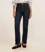 Pantalón de jean de corte slim, color azul oscuro, con trabillas en la cintura, cierre por botón y cremallera, bolsillos y aberturas en los bajos.