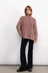 Sweater de tejido de punto con diseño de trenzas verticales, cuello redondo y silueta oversize de corte largo.