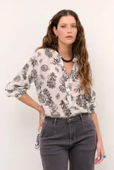 Camisa blanca de manga larga con estampado botánico en tono oscuro, cuello mao y escote en V con cierre frontal parcial de botones.