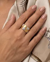 Anillo ancho de bronce con baño de oro, acabado texturizado tipo malla y detalles de estrellas incrustadas con circonias.