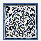 Pañuelo cuadrado de seda con estampado de accesorios de viaje y bolsos en tonos azules, verdes y negros sobre fondo blanco. Presenta un borde con franjas decorativas en azul y verde.