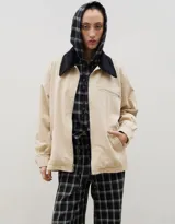 Campera de jean azul oscuro con cuello de pana en color crema. Presenta cierre frontal metálico, bolsillo con cierre en el pecho y bolsillos laterales. Diseño de corte holgado con mangas largas.