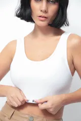 Top corto blanco de morley premium con escote redondo bajo y elástico afelpado con logo de la marca en el bajo busto.